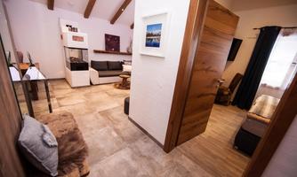 A modern living room with wooden details and a cozy atmosphere. The rooms are bright and cheerfully furnished.