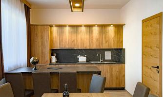 A modern kitchen with wooden furniture and elegant lighting. The dining area is cozy and inviting, perfect for social evenings.