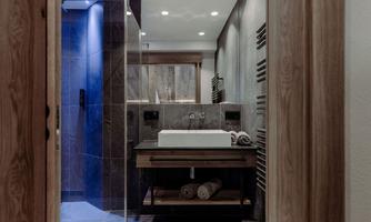 A modern bathroom with an elegant shower and washbasin made of wood. The atmosphere is stylish and inviting.