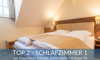 A cozy bedroom with a double bed, wardrobe, and desk. The room is bright and modernly furnished, with a smart TV for entertainment.
