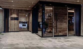 A modern entrance area with glass doors and wooden paneling. The atmosphere is inviting and stylish.