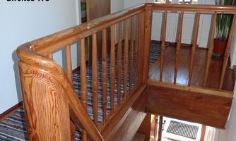 A wooden staircase with a view of the balcony door. The hallway is bright and friendly, with a green corner.