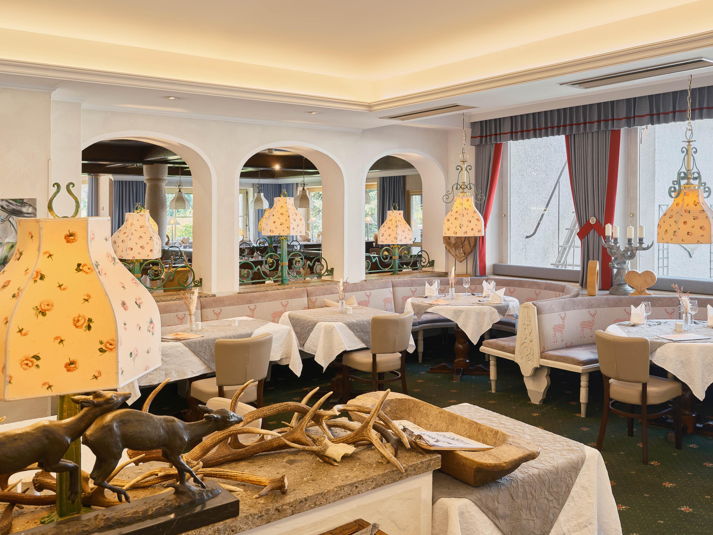An elegant restaurant with cozy tables and stylish decor. The warm light fixtures and decorative elements create an inviting atmosphere.