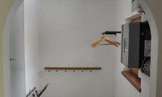 A ski room with a wooden bench and hanging options. The room is bright and simply designed.