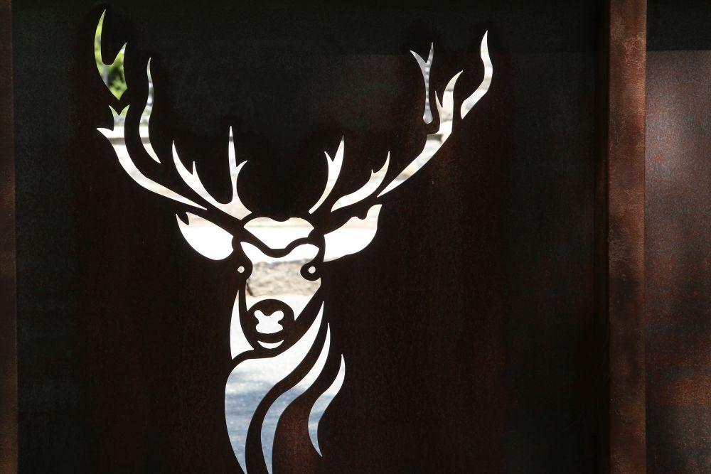A stylized deer motif is cut out on a dark surface. The details of the antlers and the face are clearly and concisely visible.