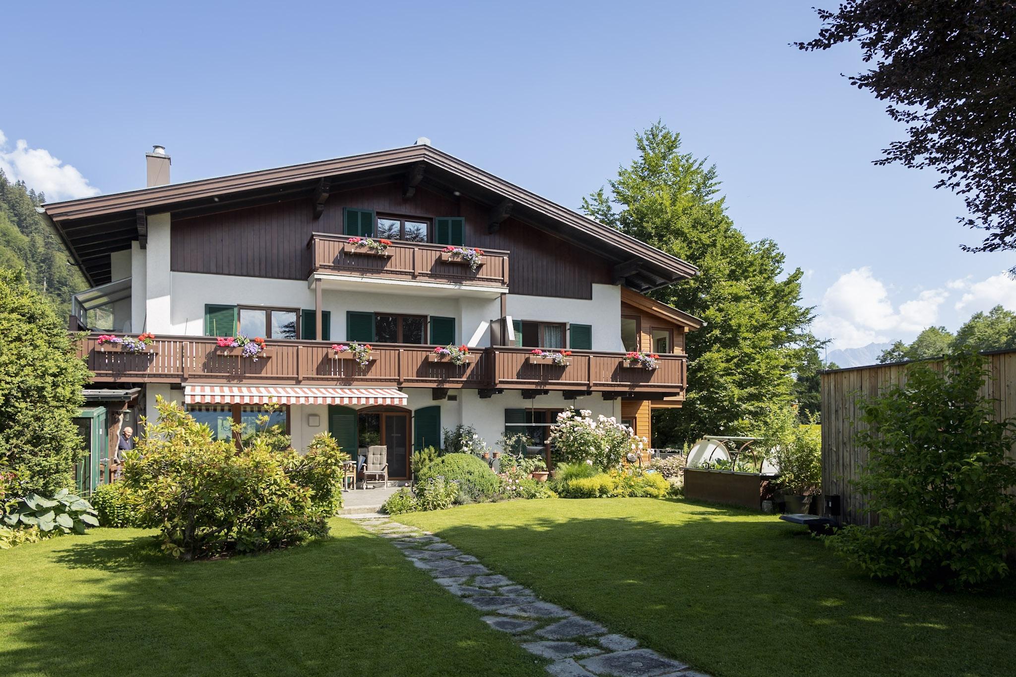 A beautiful house in alpine style with balconies and flowers. The well-kept garden and the surrounding nature give the place an inviting atmosphere.