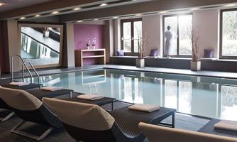An elegant indoor pool with comfortable loungers. Large windows provide plenty of daylight and a relaxed atmosphere.