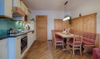 A cozy kitchen with wooden interior and a dining table. The space is bright and inviting, perfect for shared meals.