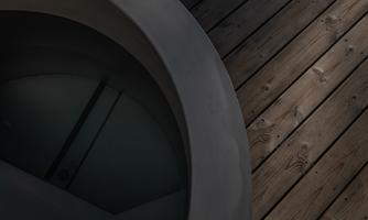 An elegant round shape on a wooden surface. The contrast between the dark material and the lighter wood creates a modern atmosphere.