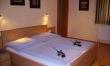 A cozy bedroom with a double bed and soft lighting. Pictures hang on the wall, and the room feels inviting and calm.