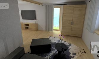 A cozy living room with a TV, a sofa, and a coffee table. Large windows offer a view of the water.