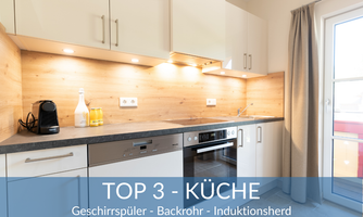 Modern kitchen with elegant white cabinets and wood paneling. Equipped with dishwasher, oven, and induction stove.