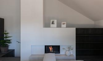 A modern living room with minimalist design. A cozy fireplace and stylish decorations create an inviting atmosphere.