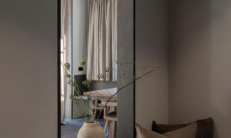 An elegant mirror frames a stylish interior design. In the background, curtains and a cozy seating piece can be seen.