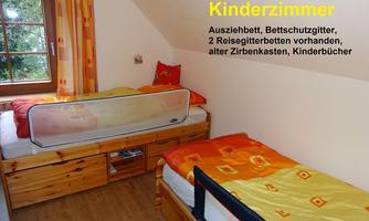 A cozy children's room with two twig beds and colorful bedspreads. The room is bright and invites playing and relaxing.