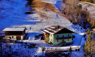A charming house in the midst of snow-covered hills. Surrounded by trees and a tranquil landscape.