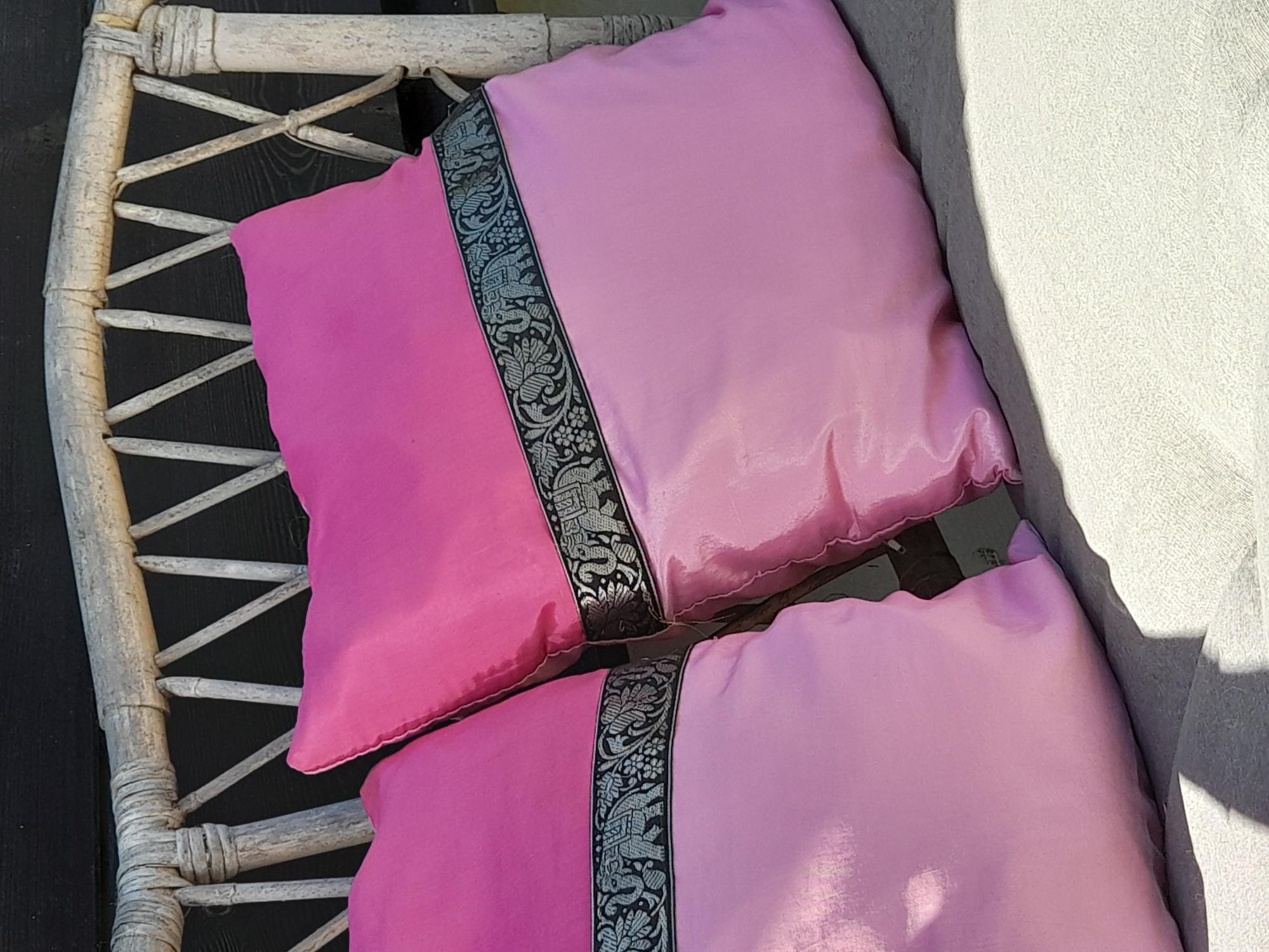 Two pink cushions with a black pattern are placed on a light bench. They give the room a cheerful and inviting look.