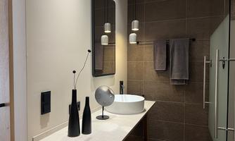 A modern bathroom with a clear design. An elegant sink countertop and stylish decorative elements create a pleasant atmosphere.