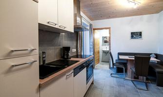 A modern kitchen with bright cabinets and a separate seating area. The room is spacious and well-equipped.