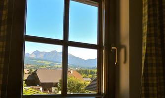 A view from a window of the mountains and the land. The sky is clear and blue.