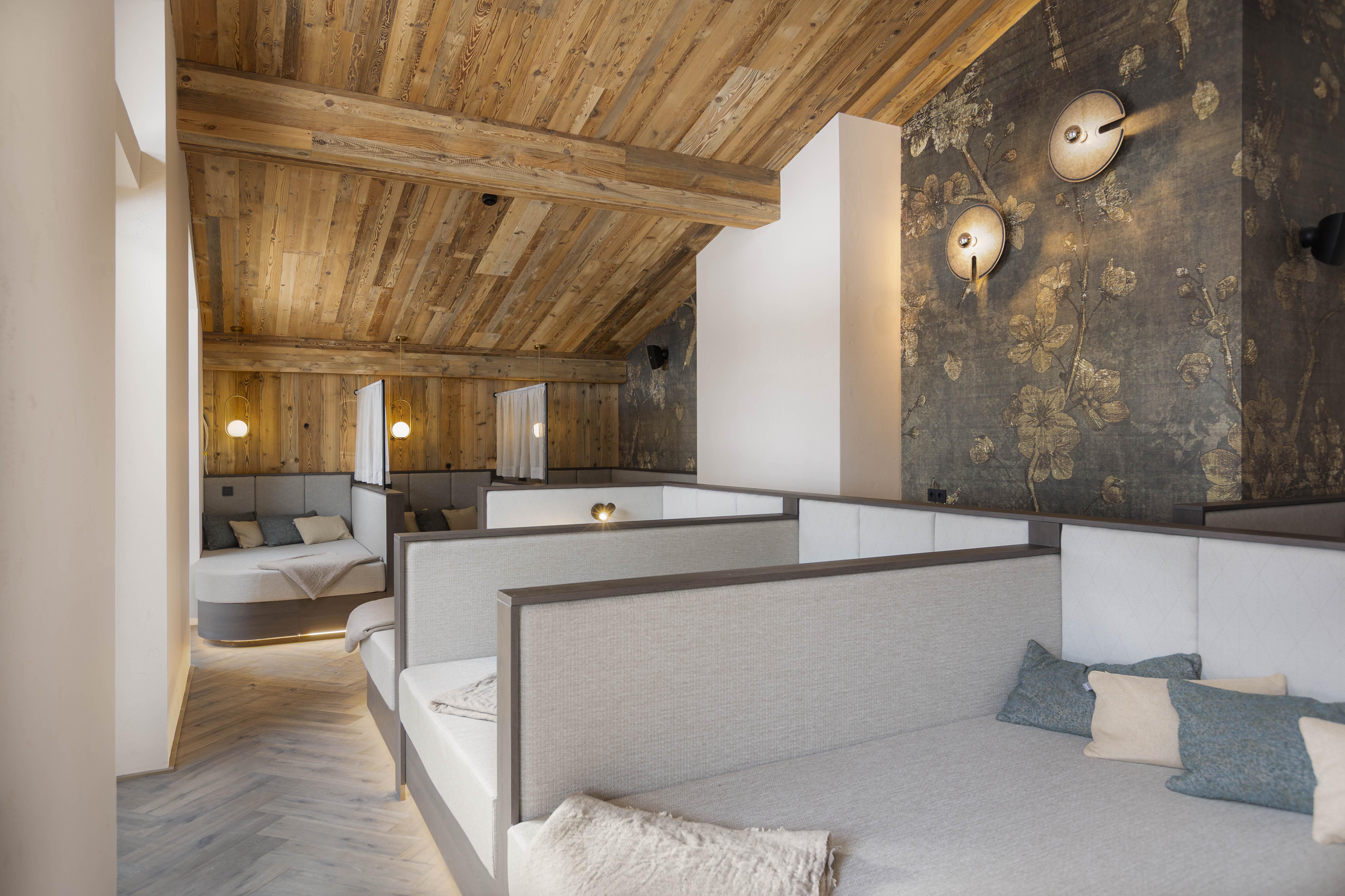 A modernly designed interior with a wooden ceiling and elegant beds. The soft lighting creates an inviting atmosphere.