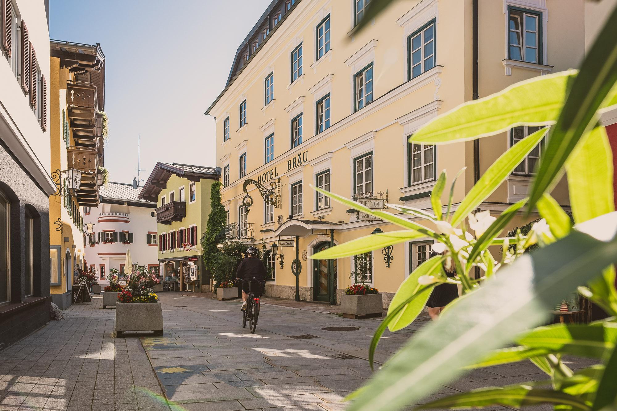 A picturesque alley with charming buildings and an inviting hotel. Green foliage frames the scene and creates a cozy atmosphere.
