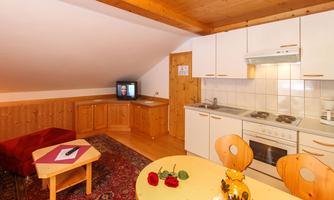 A cozy accommodation with a small kitchen and a dining area. The living room features a television and an inviting atmosphere.