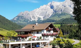 A beautiful house in the mountains with a view of majestic peaks. Surrounded by green meadows and a quiet road.