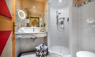 A modern bathroom with a shower cubicle and a sink.
