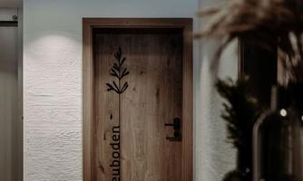 A bright hallway with a wooden door labeled "Hayloft." There are decorative plants and elegant furnishings.