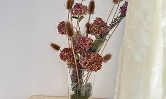 Dried hydrangeas in a vase on a wooden dresser in the bedroom at Apartment Postplattler, tastefully arranged.