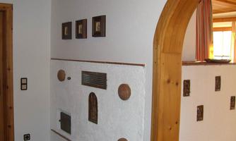 A cozy interior with a white wall and decorative elements. On the left side, there are three framed pictures.