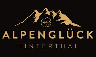 A simple, elegant logo featuring the inscription "Alpenglück Hinterthal". Above it are stylized mountains and a four-leaf clover depicted.