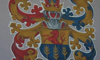 A coat of arms with colorful decorations in red, blue, and yellow. Below it says "Since 1571 the Köfer family."