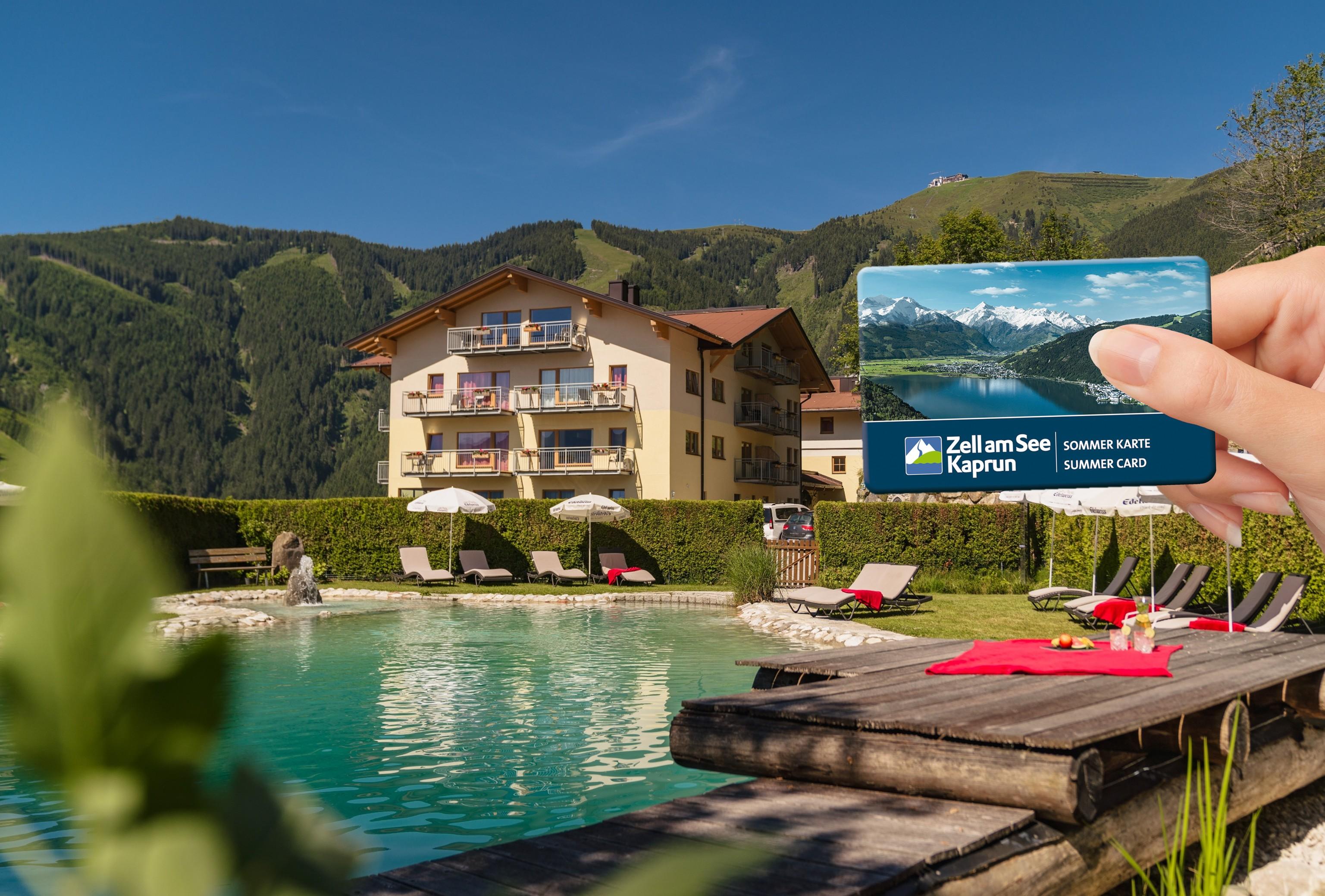 A beautiful hotel with a view of the mountains and a clear pool. In hand, someone holds a card for access to leisure facilities.