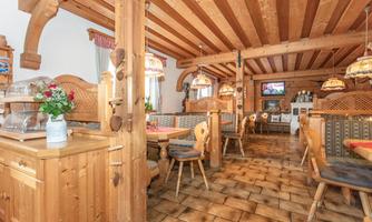 A cozy restaurant with wood-paneled walls and rustic furniture. The warm colors and ambient lighting create an inviting atmosphere.