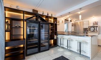 A modern kitchen with an elegant cooking area and an open shelf. The space is well-lit and has a stylish, contemporary design.
