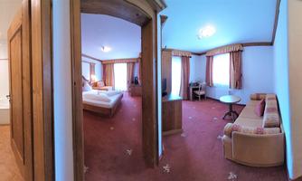 A cozy hotel room with many windows and beautiful light. The room is equipped with a bed, a couch, and a bathroom.