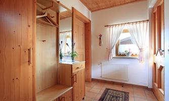 A bright hallway with wooden cabinets and a window. The room has a warm, inviting character.