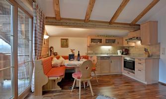 A cozy kitchen with wooden decor and a dining area. The space is bright and inviting, ideal for sociable meals.