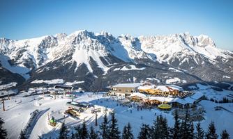 A beautiful winter landscape with snow-covered mountains. In the foreground, there is a ski resort with several ski lifts and a cabin.