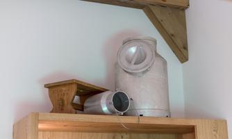 A rustic shelf with an old milk churn and a wooden scale. The items are simple and give the room a nostalgic charm.