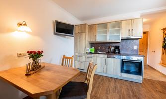 A cozy kitchen with a wooden dining table. The furniture is modern and well-equipped.