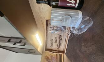 A stylish kitchen area with a wine bottle, glasses, and a decorative sign. The setting exudes coziness and an inviting atmosphere.