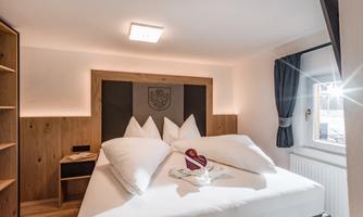 A modern bedroom with a large bed and elegant decorations. Bright colors and a cozy atmosphere provide inviting comfort.