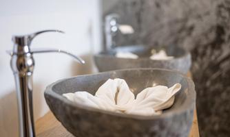 Two elegant stone sinks with white towels. A modern bathroom design with subtle fixtures.