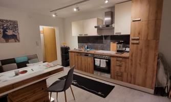 A modern kitchen with a wood look and elegant furnishings. The dining area is bright and invitingly designed.