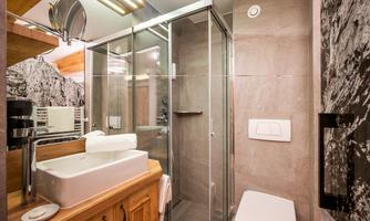 A modern bathroom with a glass shower and a stylish sink. The walls are painted in neutral tones, creating a calm atmosphere.