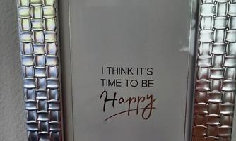 A beautiful picture frame with an inspiring quote. The text says: "I think it's time to be happy."
