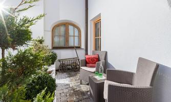 A cozy terrace with two chairs and a small table.  
Surrounded by green plants and a peaceful atmosphere.